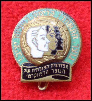 Enamel emblem pin of the World Federation of Democratic Youth (WFDY). The round pin shows two 