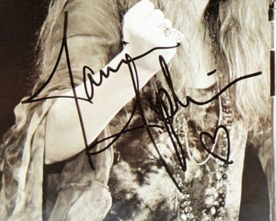 Janis Joplin signed photo. 9 in by 7 in Photo of Janis on Stage Performing. Signed: Love Janis 