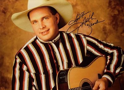 Garth Brooks signed photo. 11 in. by 14 in. Promotional photo autographed as: God Bless Garth Brooks.