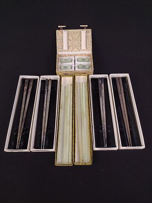 Grouping of Steel & Jade Chopsticks & Rests. 4 boxes contain one pair each of steel chopsticks. 