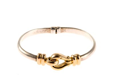 14K Gold and Sterling Silver Bracelet. A hinged bangle bracelet with one portion in 14k yellow 