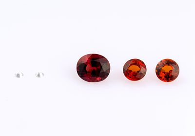 5 Loose Gemstones. Includes (2) .05 ct diamond, (2) round garnet, and oval synthetic spinel.