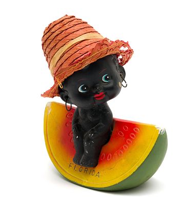 Black Americana Figural Bobble Head Bank. Circa 1940s-1960s. Features a figure sitting on a 