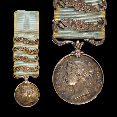 The Crimea Medal, 18mm miniature in silver, four clasps, the ribbon is pale blue with yellow edges.