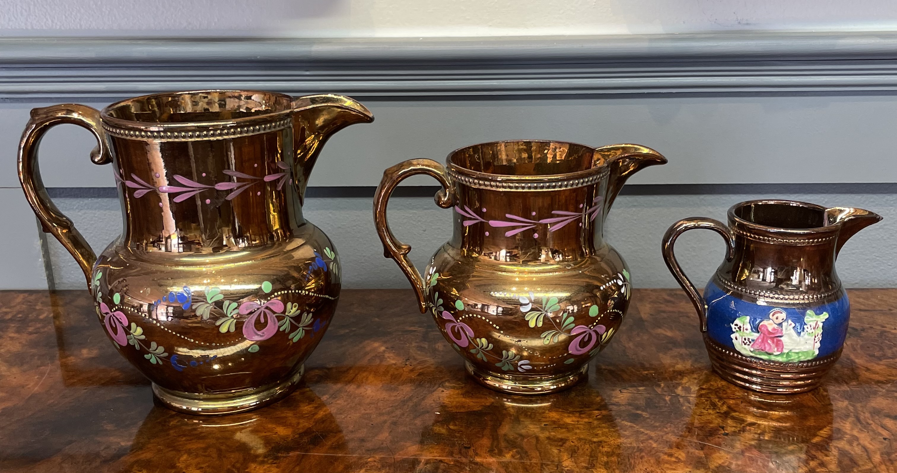 A Trio of Graduated Staffordshire Copper Luster Earthenware Jugs