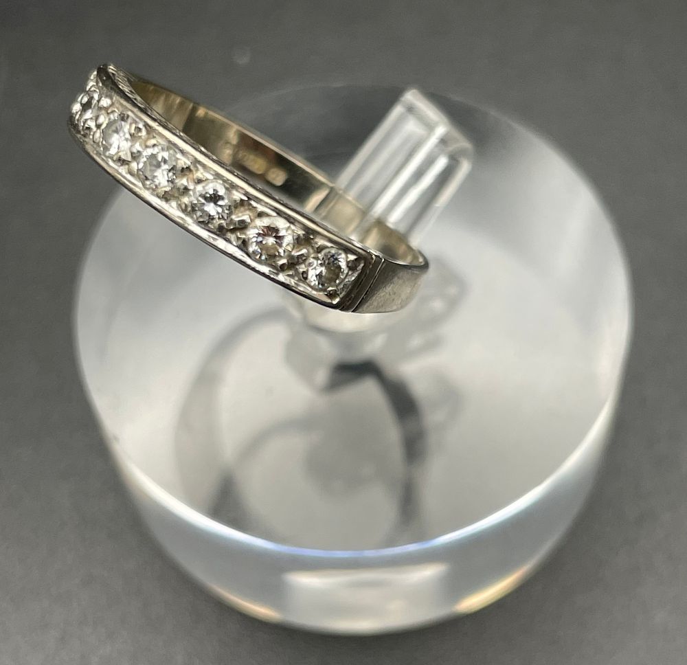 Lot 102 – An 18 Karat White Gold and Seven Stone Diamond Eternity Ring