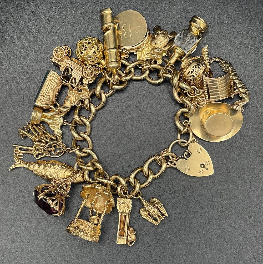 Lot 129 – 9 Karat Yellow Gold Curb Link Charm Bracelet with Heart Padlock Clasp and Assorted Charms