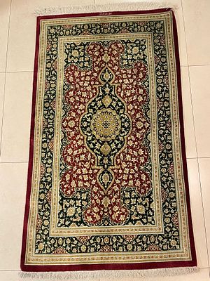 שטיח קום משי (משי על משי), בעבודת יד. 160X100 ס"מ. מדליון על רקע אדום עם מספר מסגרות. חתום.