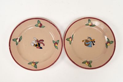 Pair of French Faience Henriot Quimper Apple Pattern Plates. One plate depicts a man playing 