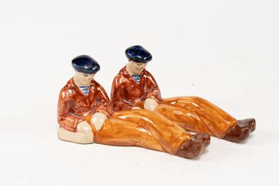 Pair of French Faience HB Quimper Sitting Sailor Figures. Sailors have blue hats, red shirt 