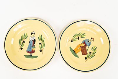 Pair of French Faience Yellow Plates. 1 plate depicts a man carrying a drum and 1 plate depicts 