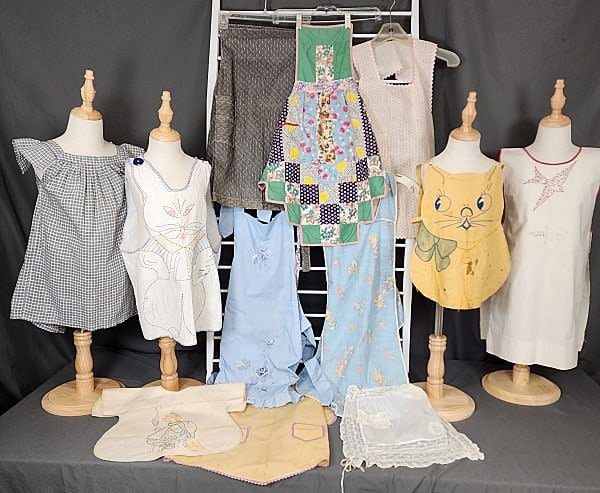 Lot 214: 12 Vintage Child Aprons and Pinafores