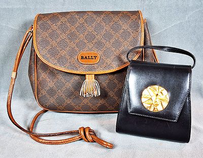 2 Small Leather Crossbody Bags. There are 2 small crossbody bags with one by Bally and the 