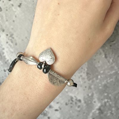 צמיד וינטג’ מקסים, המשלב תליונים מעוטרים עם אבנים שחורות