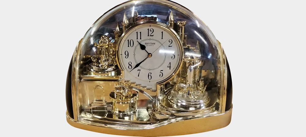 Lot 407: A Rhythm Enchanted Kingdom Gold Tone Quartz Motion Mantel Clock