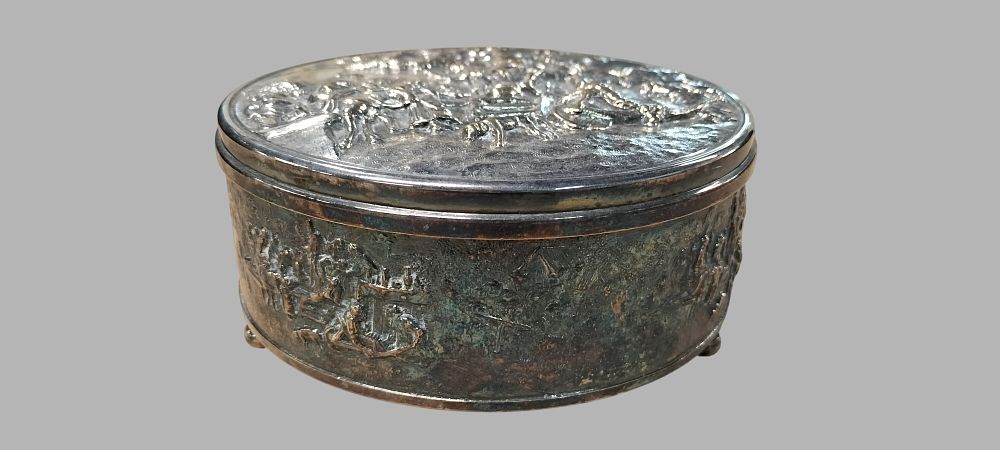 Lot 376: Continental Teniers Style Relief Decorated Silvered White Metal Circular Box
