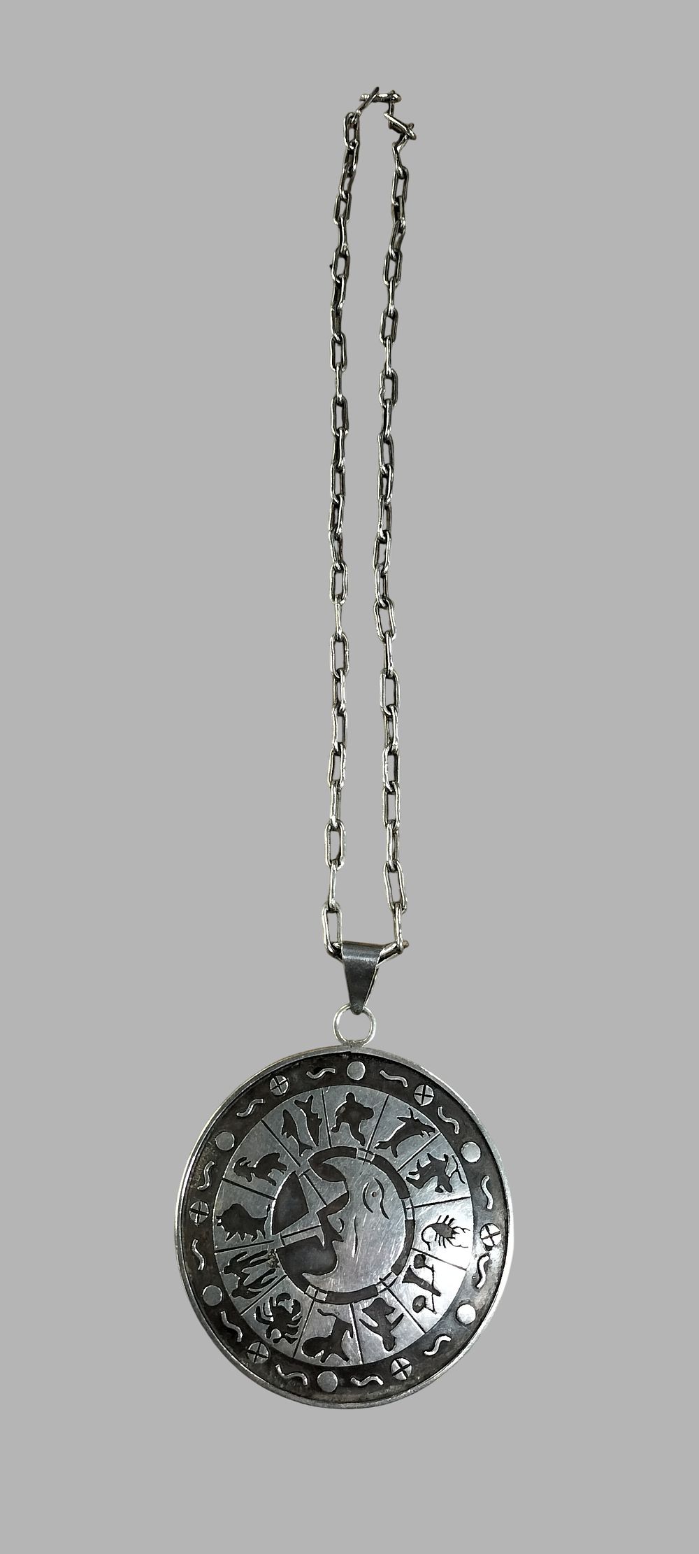Lot 382: A Mexican Sterling Silver Zodiac Medallion Pendant and Paperclip Link Chain from Taxco