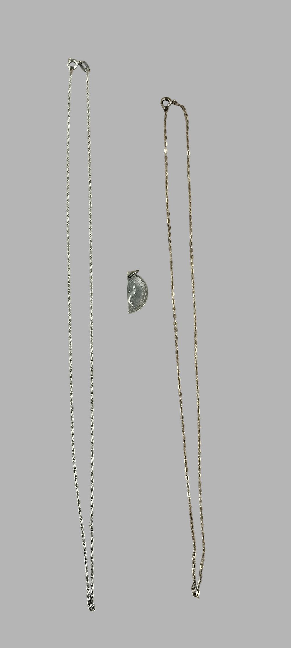 Lot 385: An Assortment of Silver Jewellery comprising Two Necklace Chains and a Novelty Coin Pendant