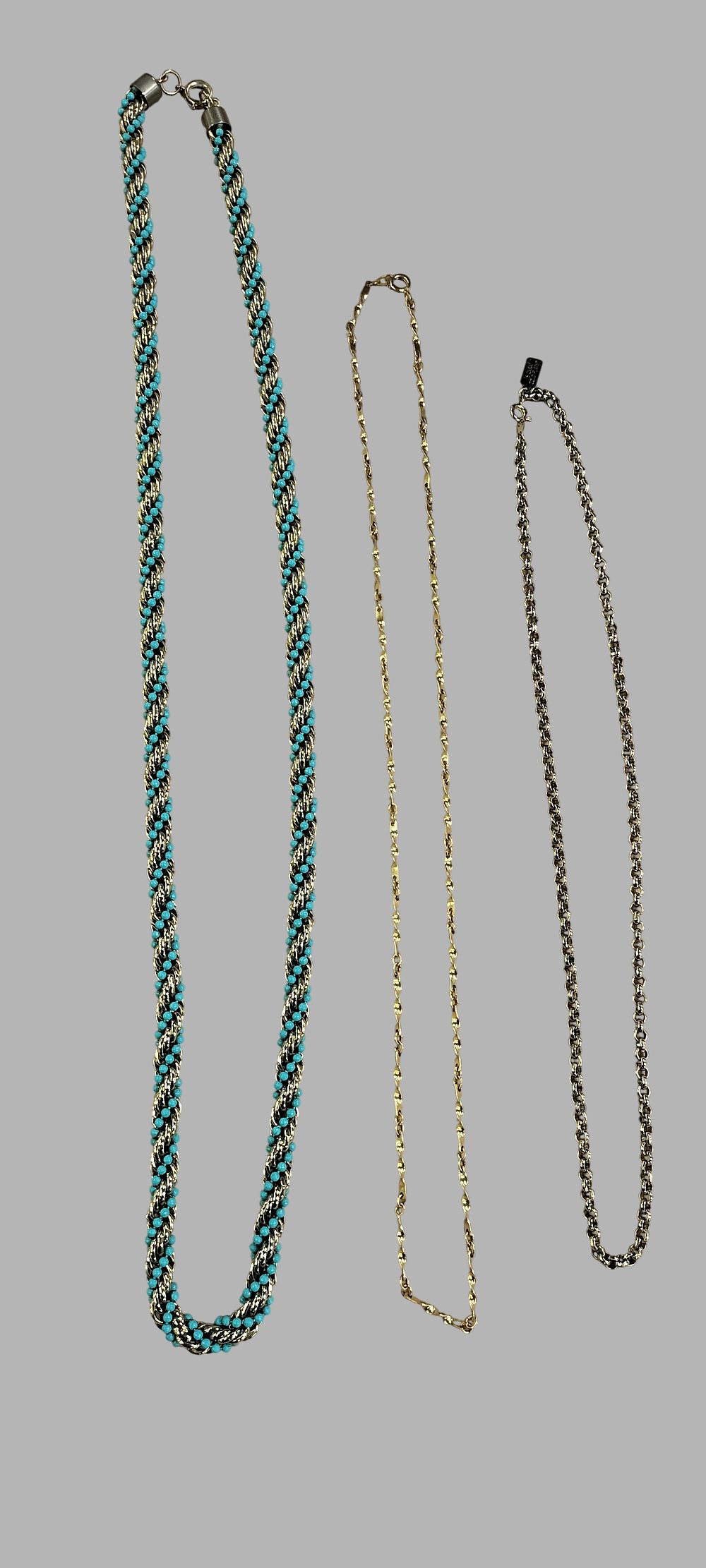 Lot 407: A Trio of Necklaces Including an Avon Rope Twist and a Nina Ricci Chain