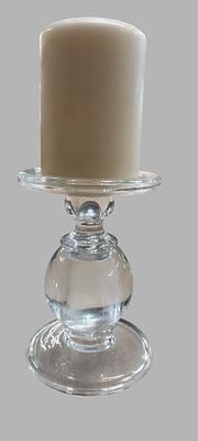 A Clear Glass Pedestal Candle Holder and White Pillar Candle