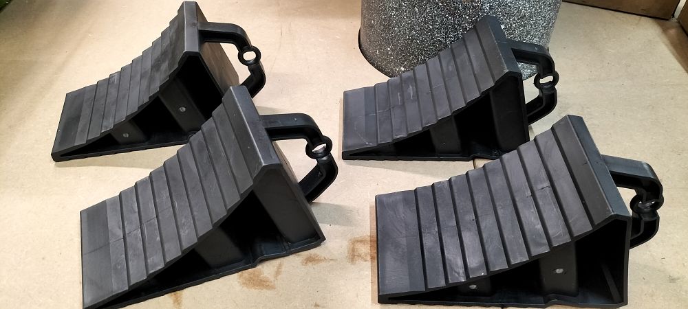 Lot 272: A Set of Four Universal Black Plastic Wheel Chocks with Integrated Handles