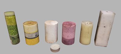 A Collection of Assorted Pillar Candles and Decorative Granules