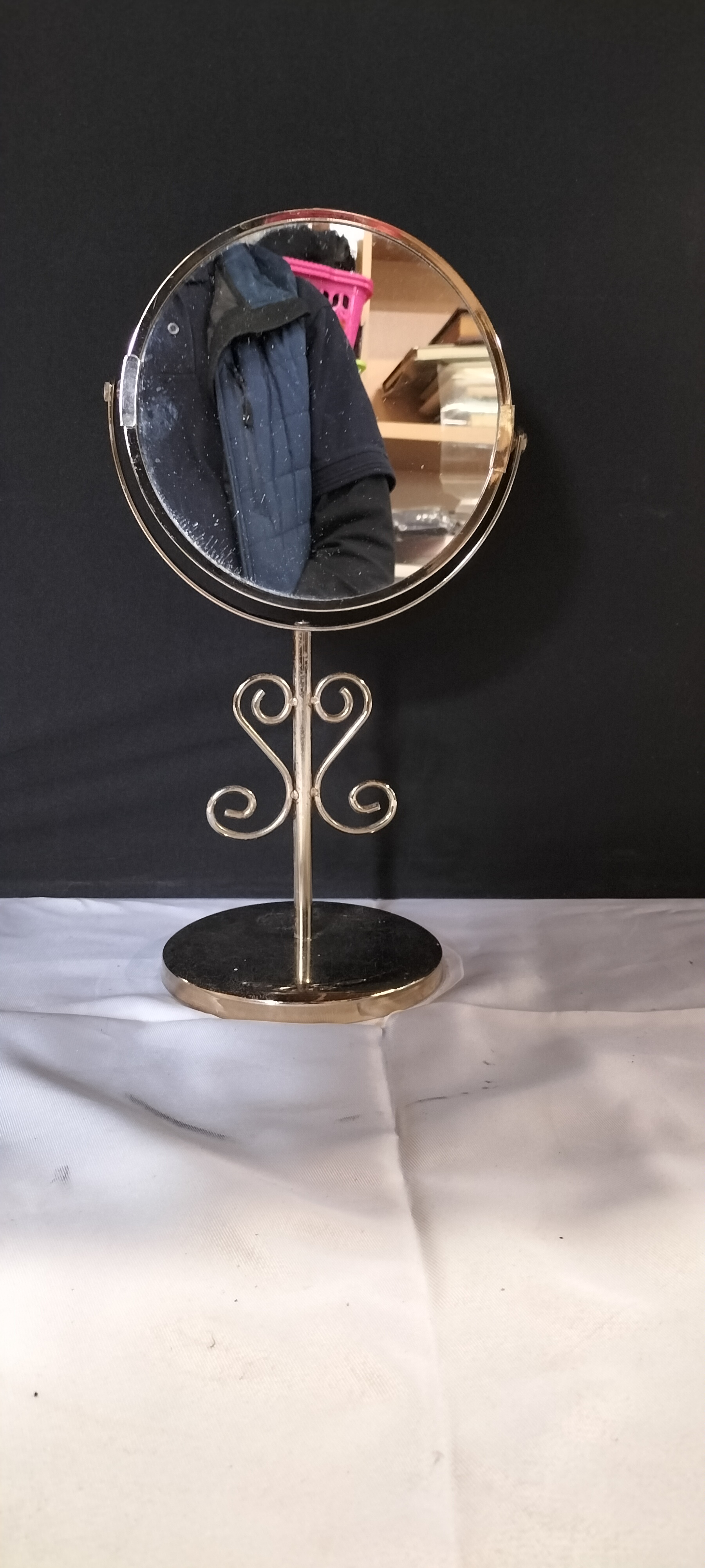 A Gold Toned Metal Double Sided Swivel Tabletop Vanity Mirror with Scrollwork Stem