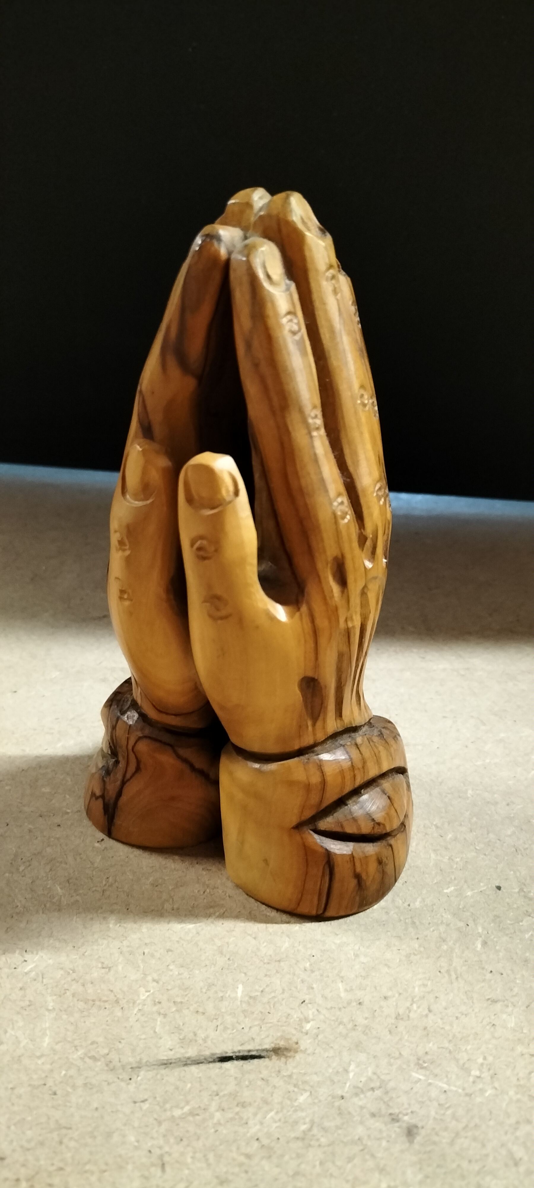 A Carved Olive Wood Praying Hands Sculpture