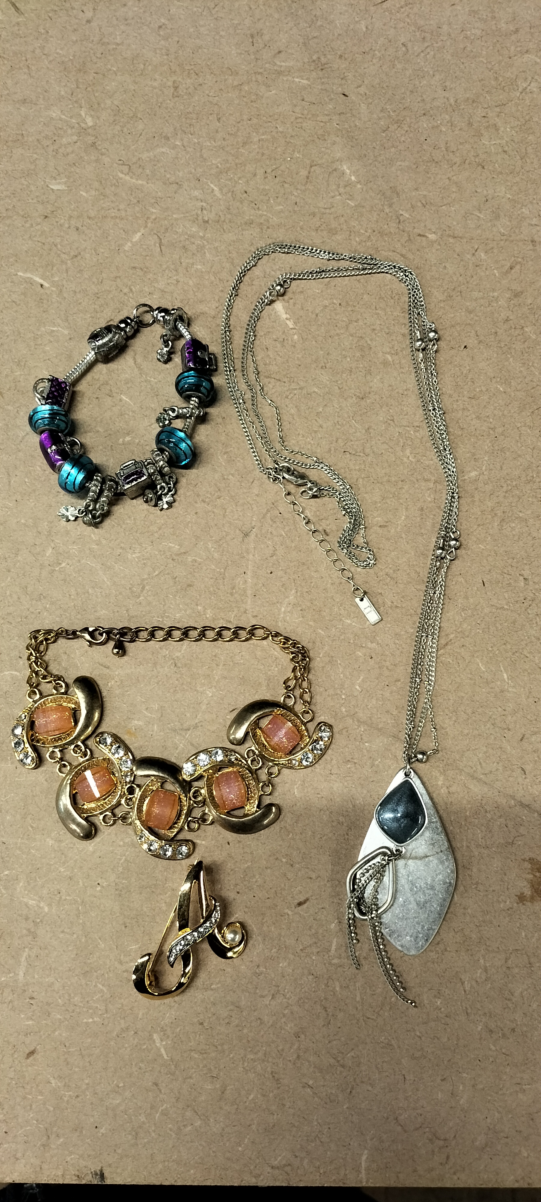 4 Mixed Base Metal Costume Jewellery Pieces Including Charm Bracelet and Initial Brooch