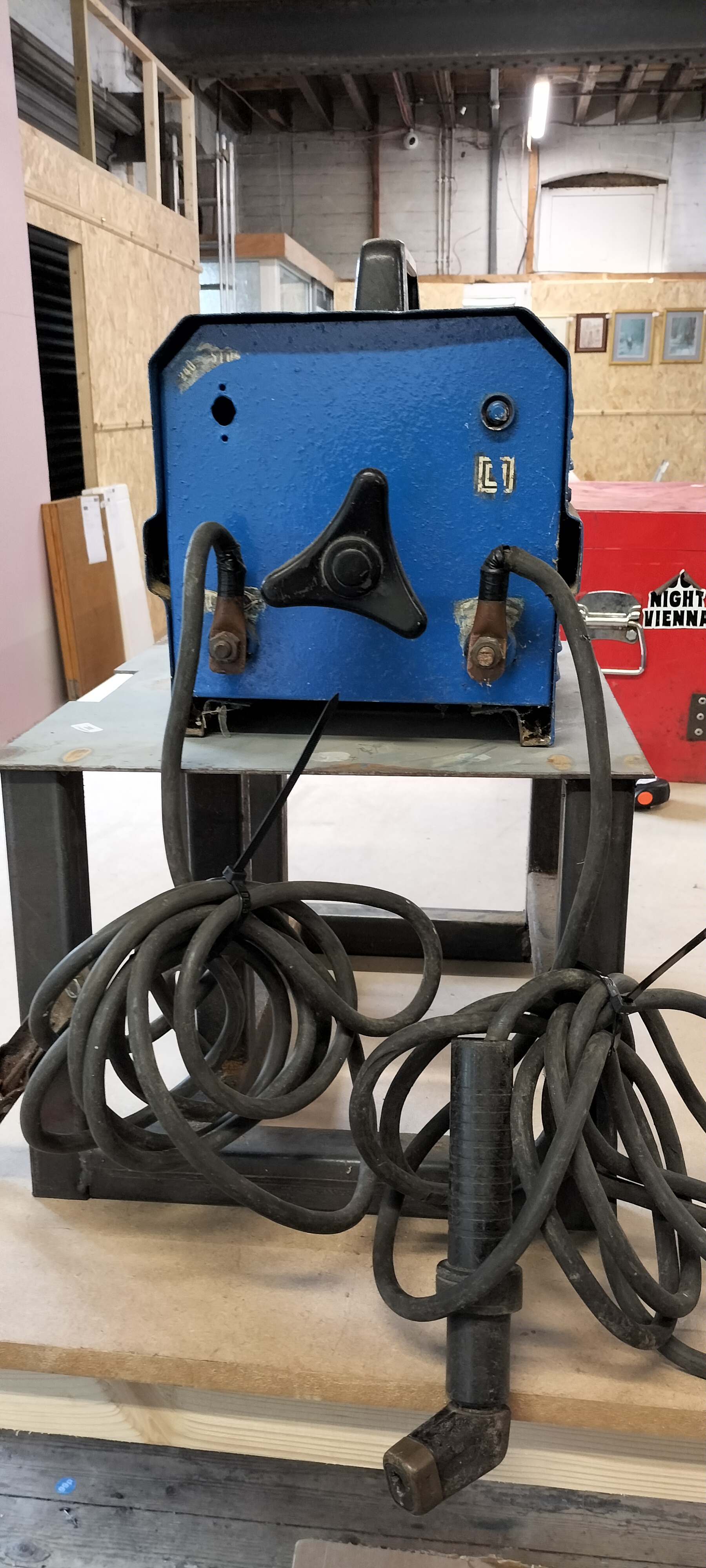 A Blue Metal Housed Transformer Type Arc Welder on Steel Stand