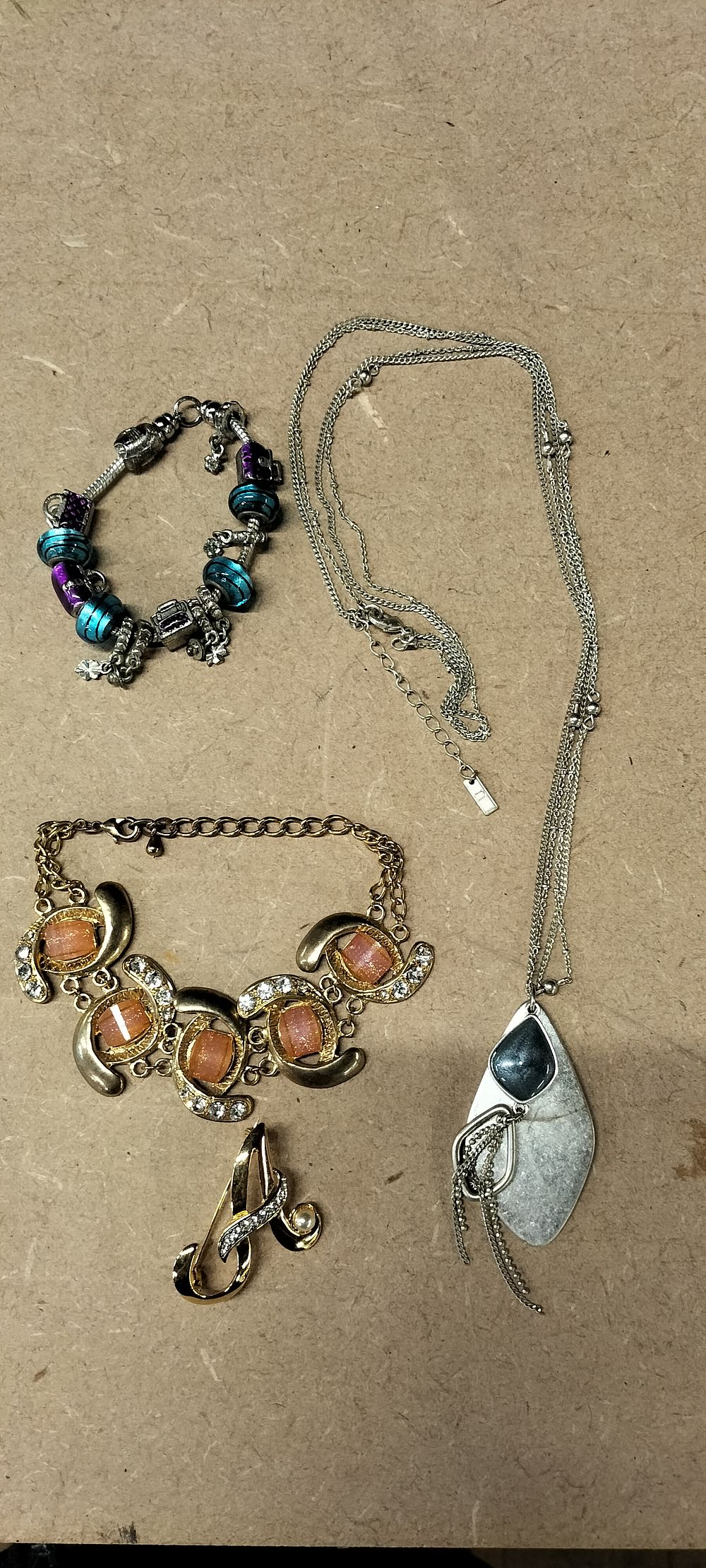 Lot 318: 4 Mixed Base Metal Costume Jewellery Pieces Including Charm Bracelet and Initial Brooch