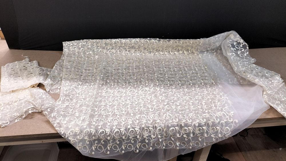 Lot 195: A Single Length of Ivory Embroidered Net Fabric with Off-Cut Fragments