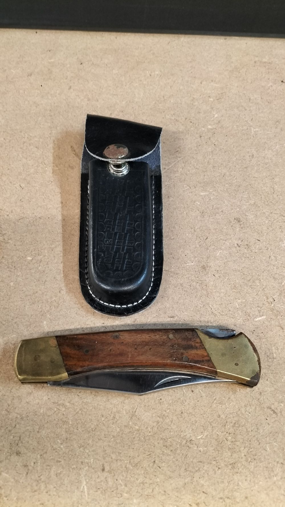 Lot 184: A Wood and Brass Stainless Steel Single Blade Lock-back Folding Pocket Knife with Leather Sheath