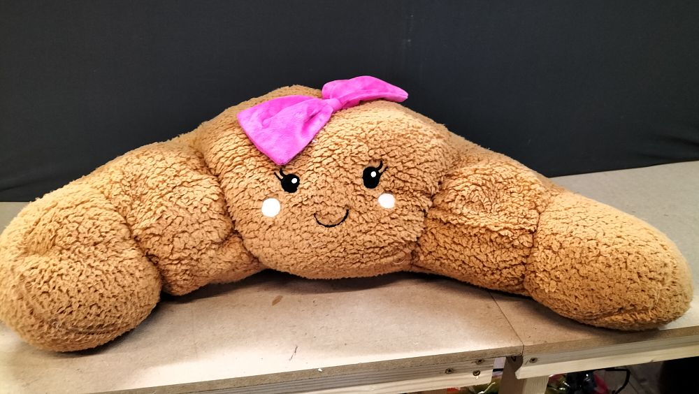 Lot 197: A Large Bowed Croissant Plush Cushion