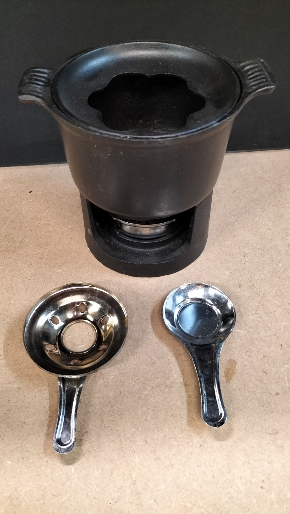 Lot 211: A Matte Black Cast Iron Fondue Set with Burner Components