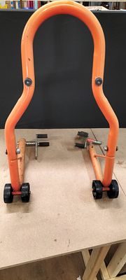 An Orange Tubular Steel Motorcycle Paddock Stand