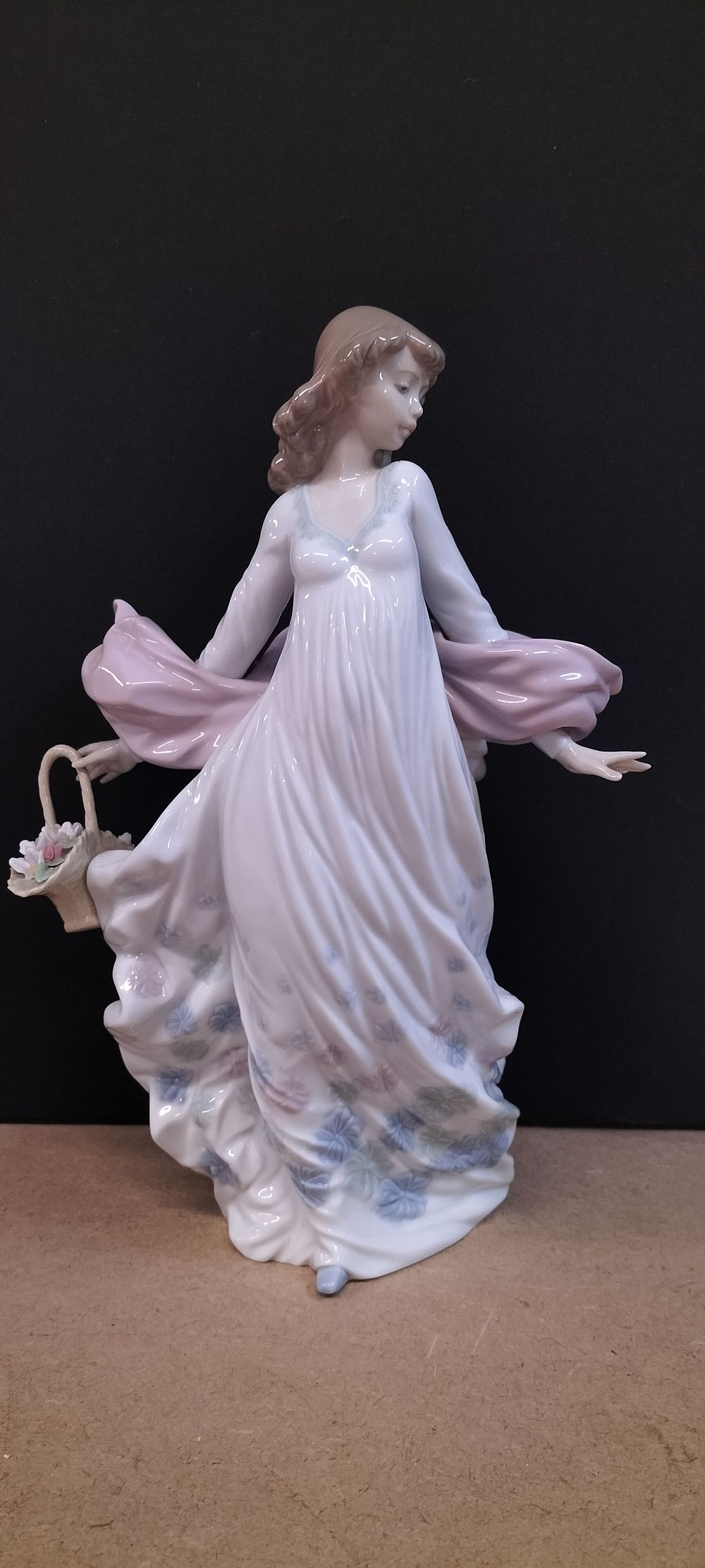 Lot 219: A 1982 Lladro Glazed Porcelain Figurine of a Woman with Flower Basket .Titled Spring Song. Sculpted by Juan Huerta. 5098 ( Retired)