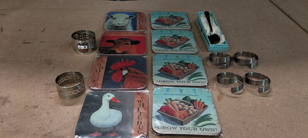 Lot 230: A Collection of 8 Farmhouse Style Coasters, 6 Napkin Rings and a Commemorative Spoon