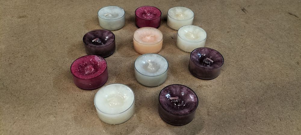 Lot 250: An Assortment of 11 Multi-Coloured Wax Tea Light Candles in Plastic Containers