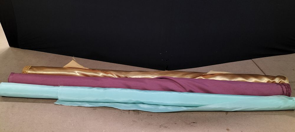 Lot 289: An Assortment of 3 Partial Fabric Bolts in Gold, Plum, and Turquoise