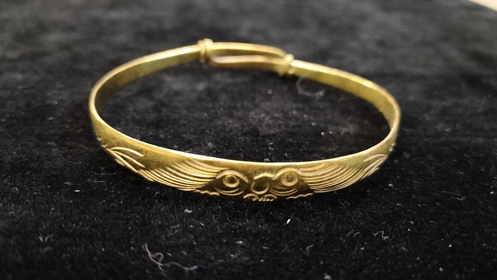 Lot 295: An Adjustable 9ct gold on Silver Bangle with Engraved Owl Motif