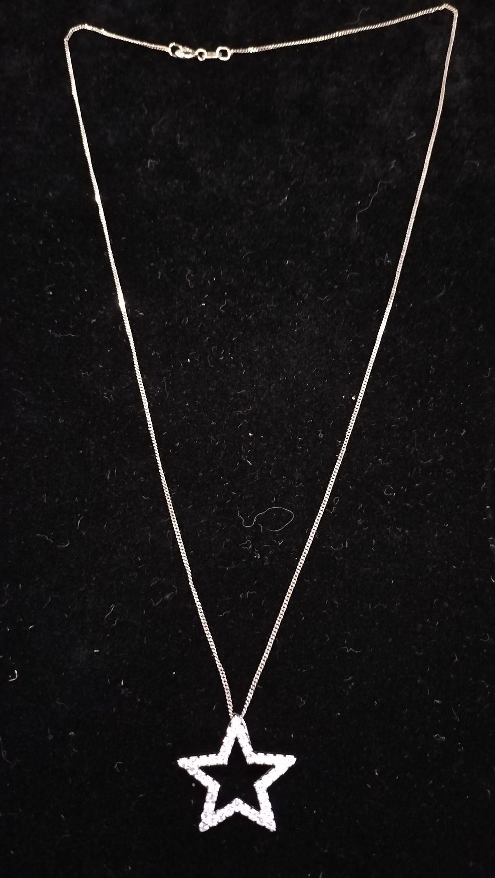 Lot 428: A Sterling Silver Open Star Pavé Set Pendant on Curb Link Chain
