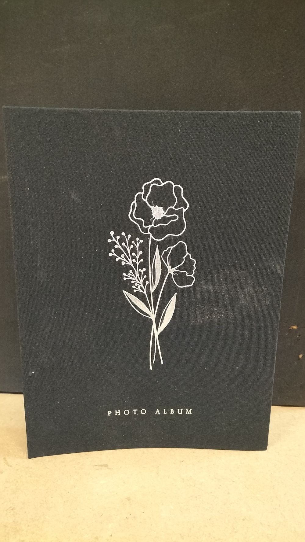 Lot 271: A Cloth Bound Photo Album with Floral Silver Toned Decoration