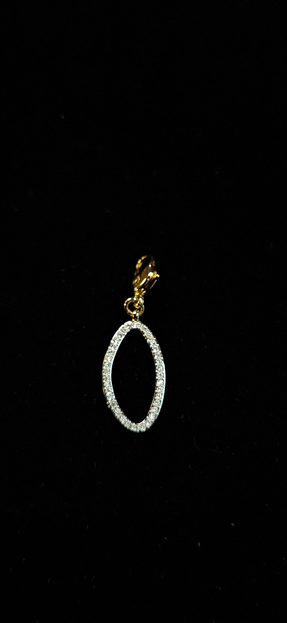 Lot 75: A Swarovski Two-Tone White and Yellow Metal Pave Set Elliptical Charm