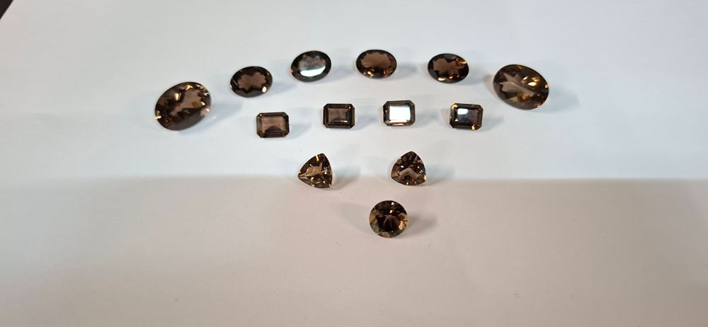 Lot 190: A Collection of 13 Faceted Chocolate and Smokey Topaz Loose Gemstones