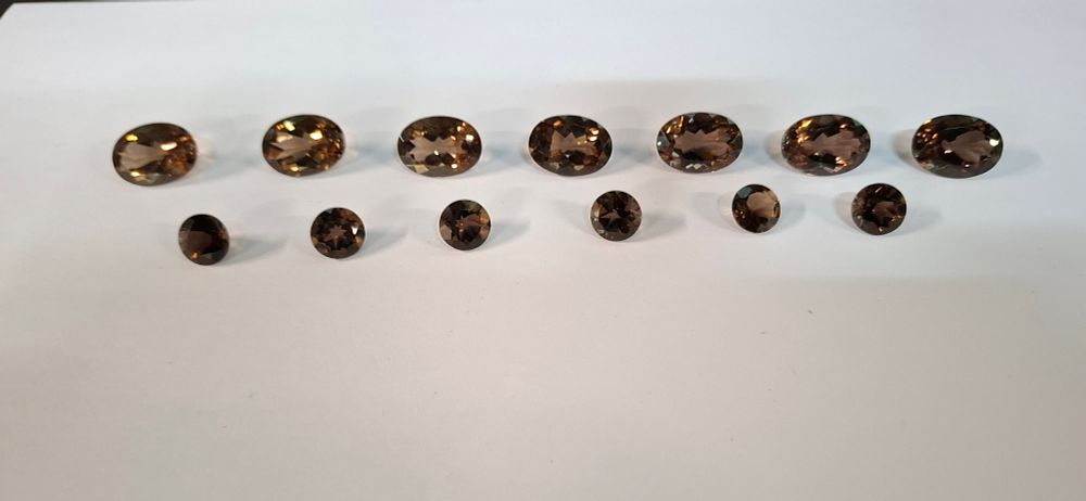 Lot 220: A Collection of 13 Oval and Round Cut Chocolate Topaz Loose Gemstones