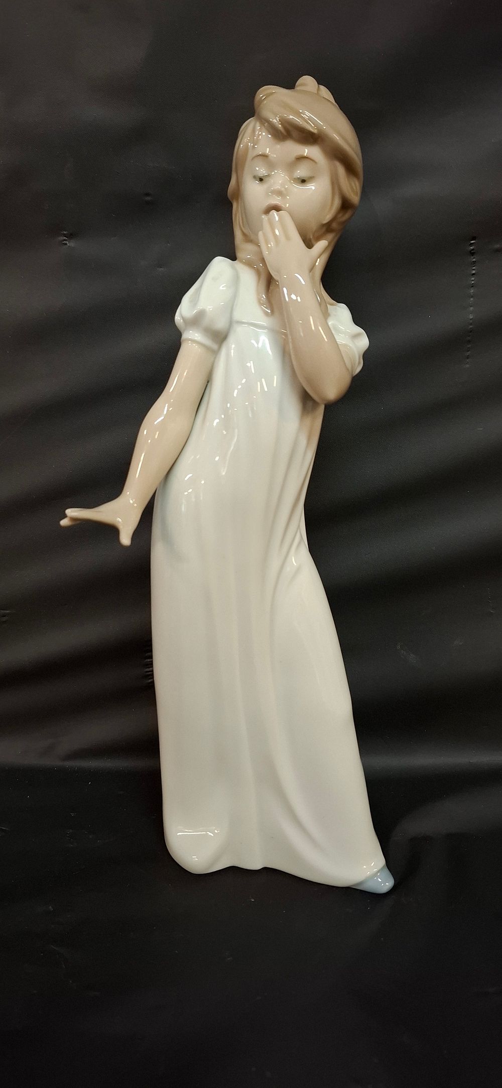 Lot 248: A Nao Porcelain Figurine of a Young Girl Yawning
