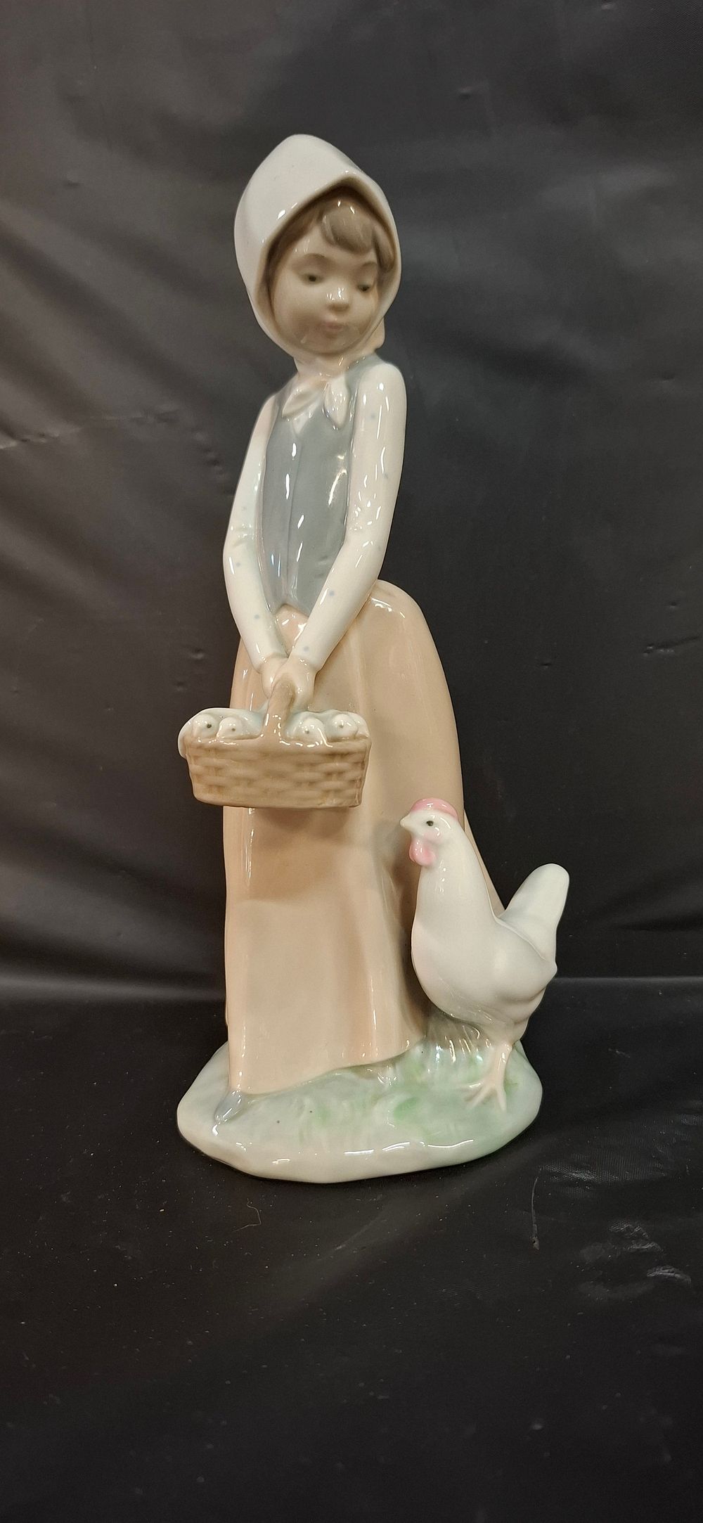 Lot 253: A NAO by Lladro Glazed Porcelain Figurine of a Girl with Chicken