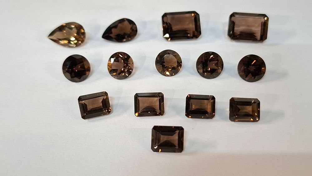 Lot 397: A Collection of 14 Smokey and Chocolate Topaz Faceted Gemstones