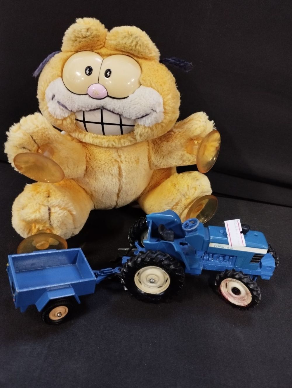 Lot 41: Vintage Car Window Garfield and Toy Tractor
